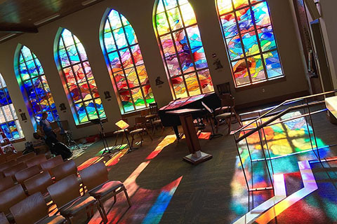 Stunning view of light cascading through stained glass inside the Hermance Family Chapel of St. Basil the Great.