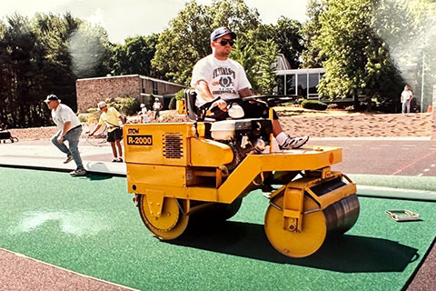 Machinery working on the football field and track area.