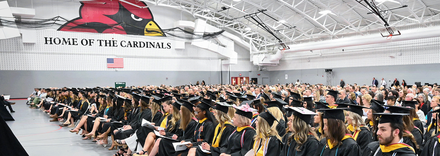 Crowd of students in commencement regalia during commencement ceremony.