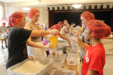 Students packing food boxes for community service.