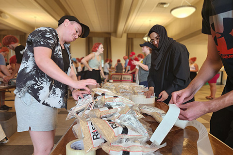 Fisher community packs food for service day.