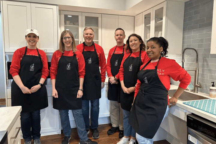 A group of six Fisher alumni pose for a photo while volunteering