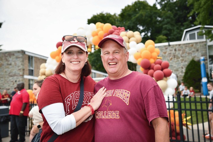 Two alumni in Fisher clothing at Alumni Weekend