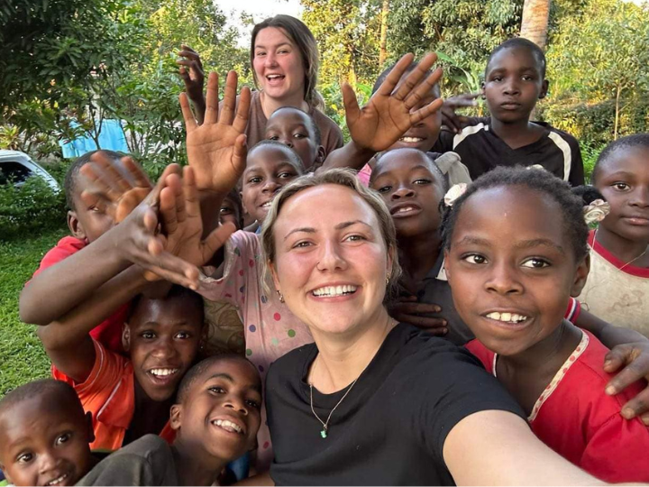 Lexi Henderson with a group of children in an outdoor setting