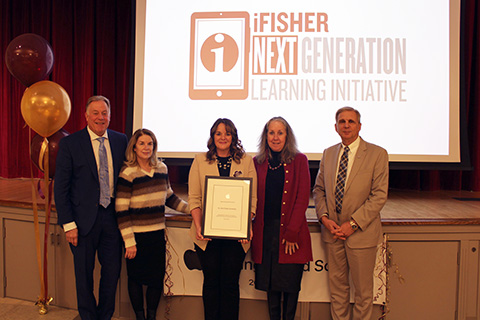 Fisher faculty and staff stand together on front of text
