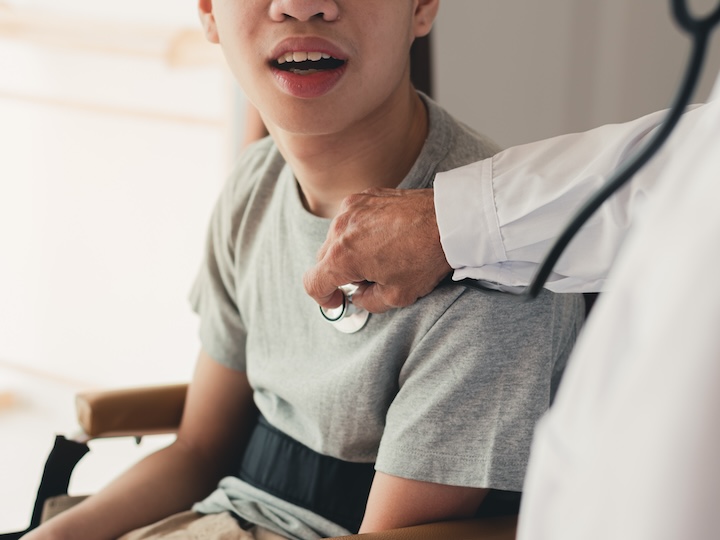 Doctor examining a patient with a stethoscope, faces out of shot