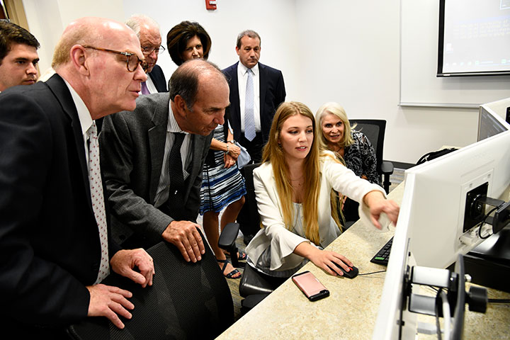 Student Emilie German offers a demo of the Bloomberg Terminals in the newly opened Walter and Barbara Parkes Trading Lab.