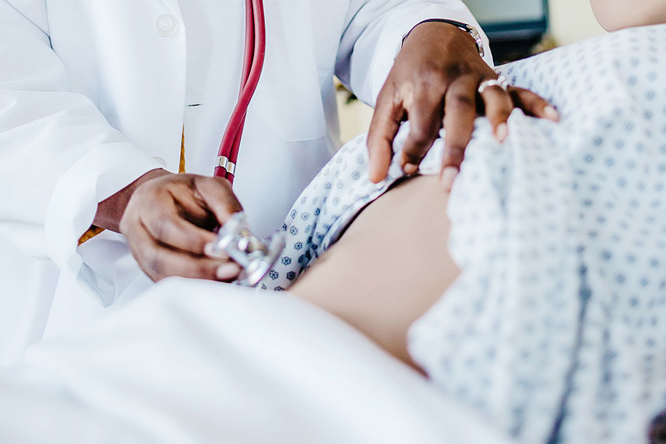 A nurse checks a patient.