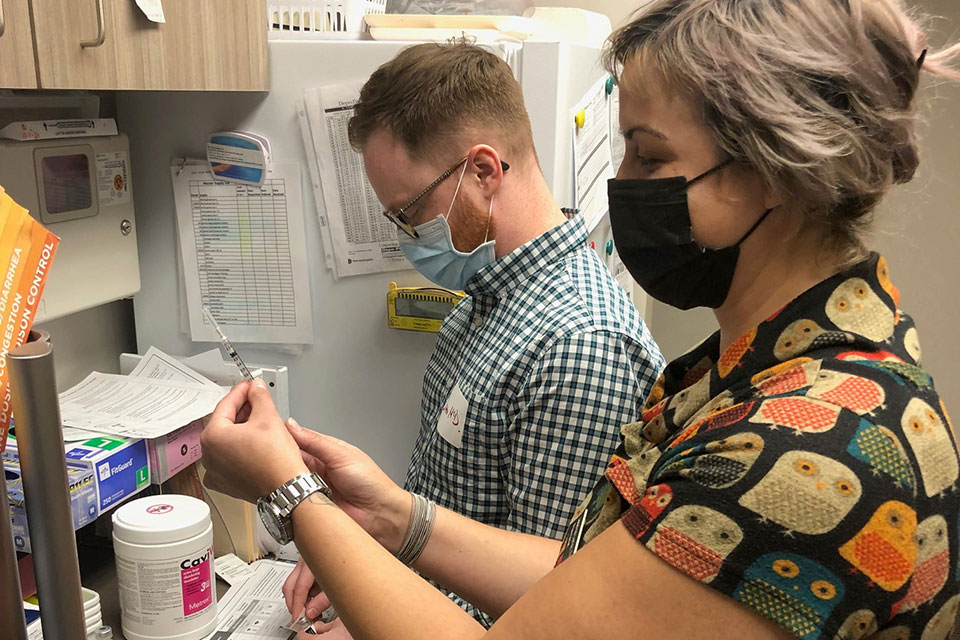 School of Pharmacy members draw up vaccines during a clinic.