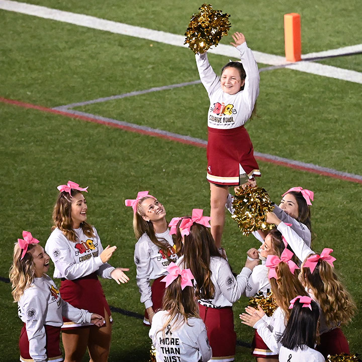 Fisher cheerleaders lift Karleigh Sackett in a stunt.