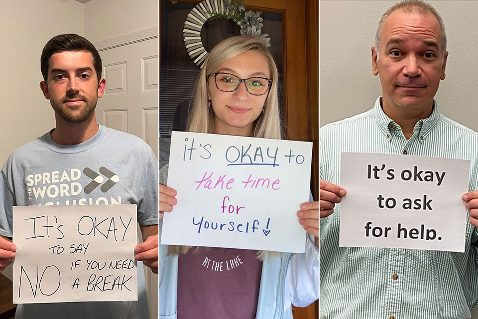 Students and employees hold up signs with words of encouragement.