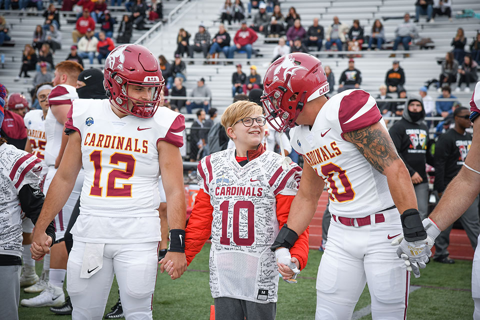 Honorary Coach Jack Harrison walks out for the coin toss with Fisher players.