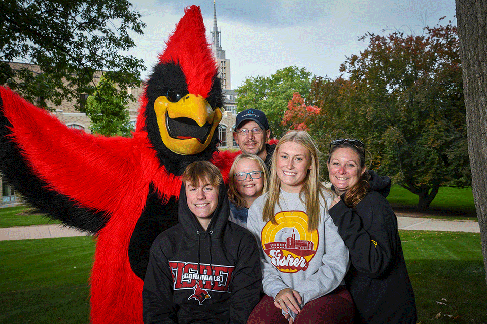 Cardinal poses for a portrait with a Fisher family.