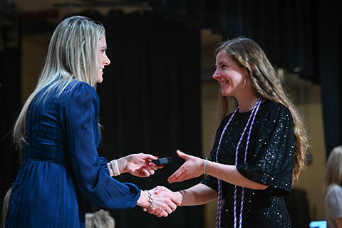 A graduate of the School of Nursing receives their pin.