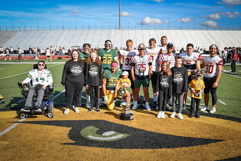 Members of the SUNY Brockport and Fisher football teams pose with the honorary coaches after the Courage Bowl.