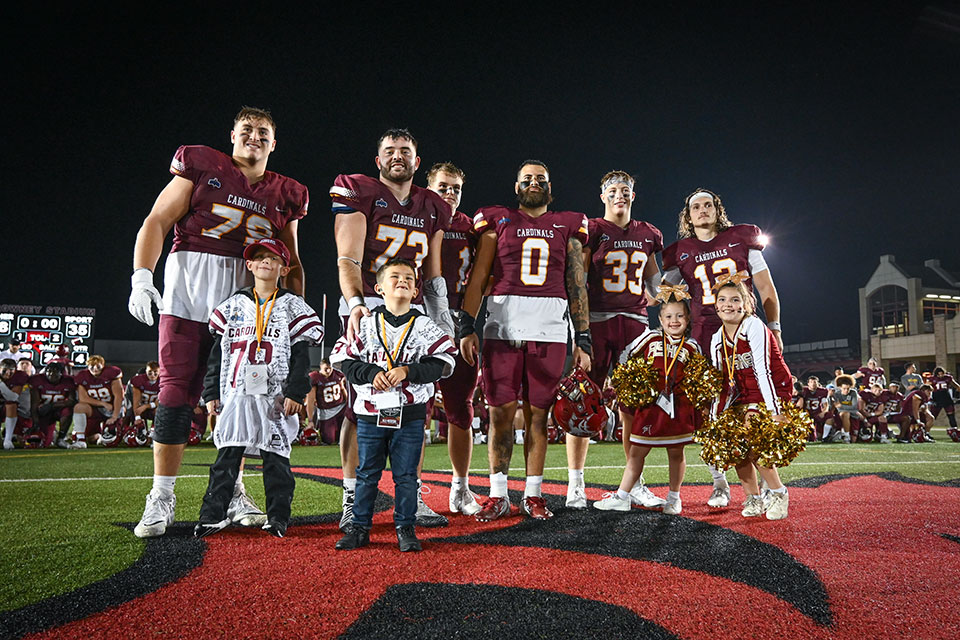 Fisher football players with the honorary coaches and cheerleaders from Camp Good Days during the 2023 Courage Bowl.