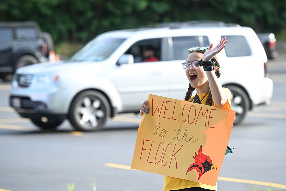 A student holds up a welcome sign.