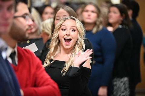 A student waves during the nursing pinning ceremony.
