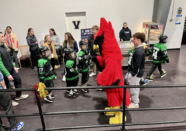 Youth hockey players meet Beaks during a Fisher hockey game.
