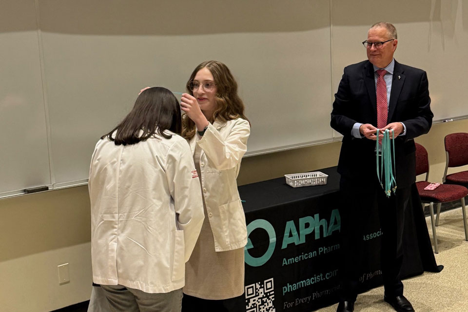 Students receive pins during an induction ceremony.