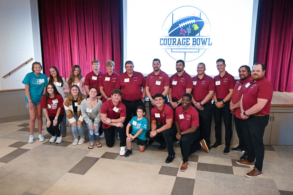 The Fisher football and cheer teams with honorary coaches and cheerleaders at the Courage Bowl Luncheon.
