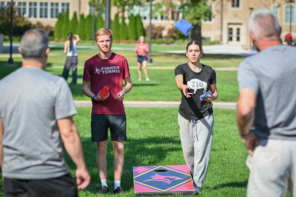 Fisher students and their dads play a friendly game of corn hole during Family Weekend.