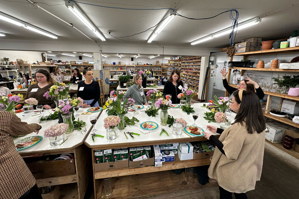 Attendees make floral arrangement at the first Blossoms and Beverages event.