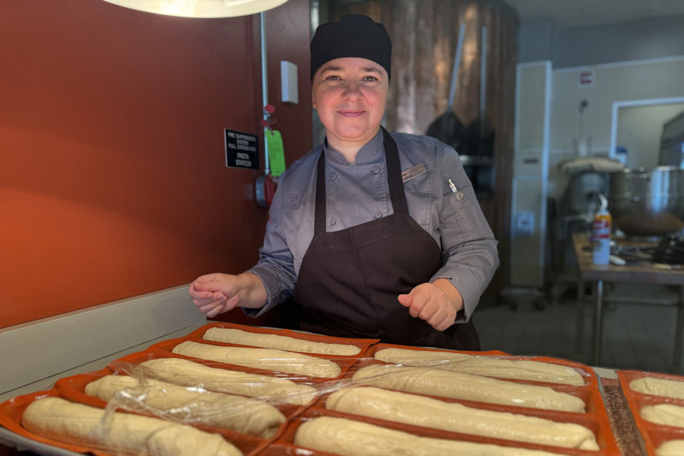Lesia Kachaluba poses with the pre-baked rolls at Ward-Haffey Dining Hall.
