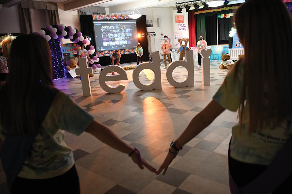 Teddi students in the foreground with the word 