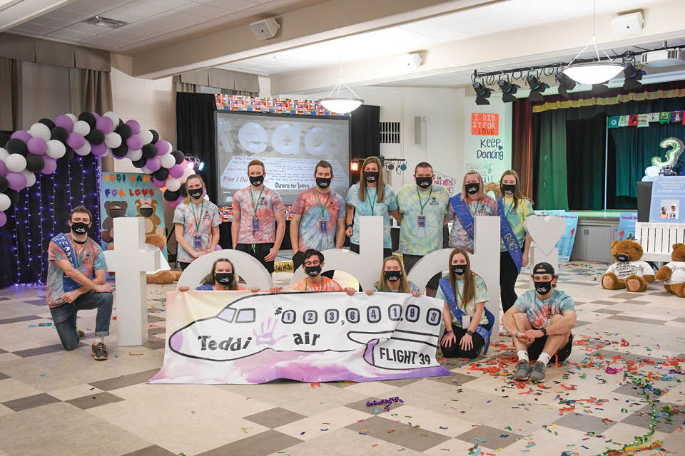 Students in the Teddi Committee gathered around a graphic depicting the final amount raised