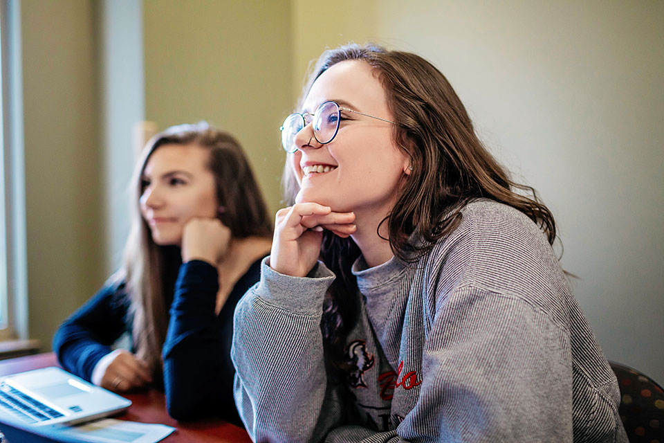 Students listen to a professor in class.