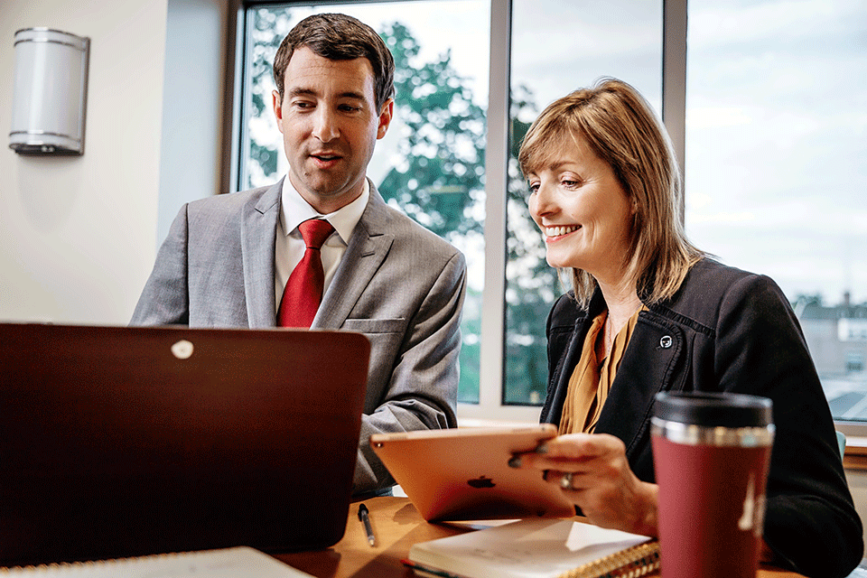 Two executives work at a table.