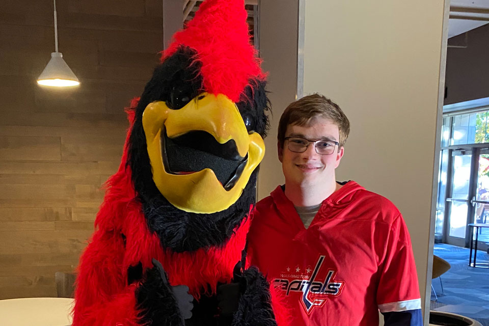 Fisher's mascot, Beaks, with student Andrew Ortolani
