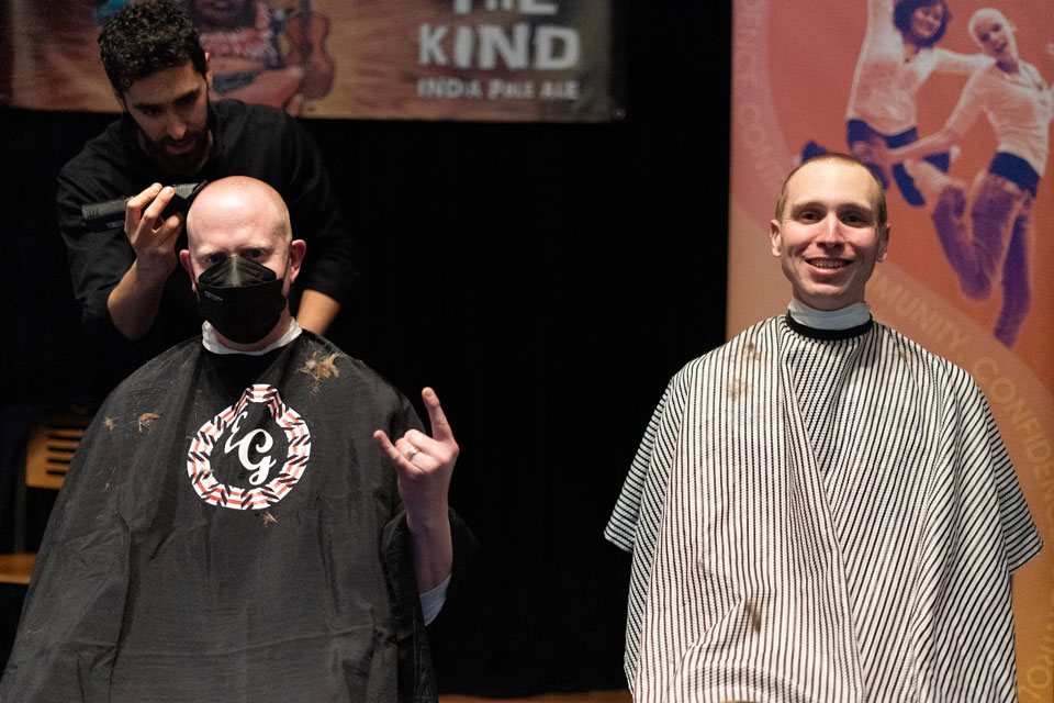 Two members of the Wegmans School of Pharmacy community shave their head during Bald for Bucks.