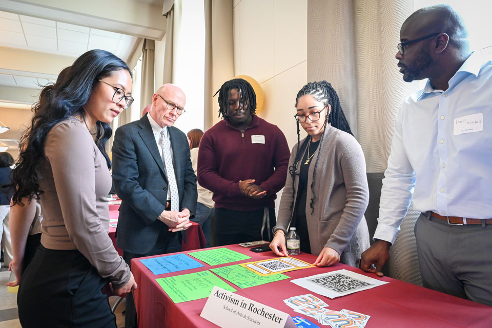 President Rooney talks with students about their presentations during hte ICCE Awards.