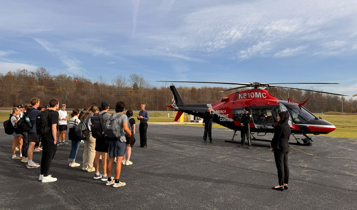 Students from the School of Business with the Mercy Flight crew and helicopter.