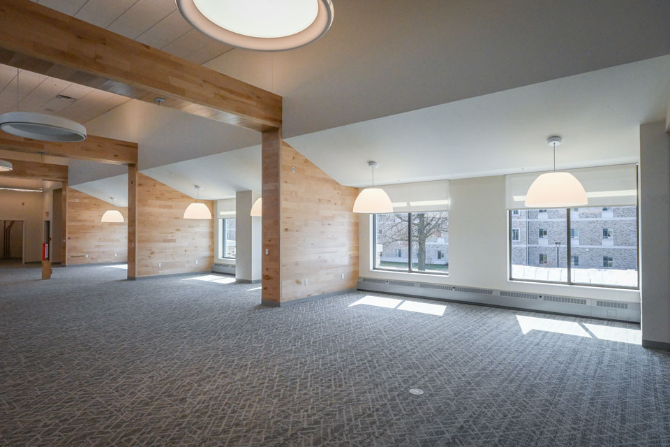 Interior spaces boast blonde wood accents, bright light fixtures, and colorful carpets.