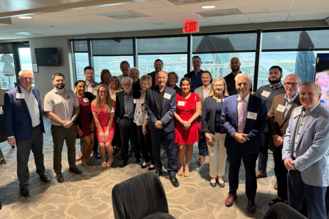 Alumni gather for a group photo at a reception in Tampa