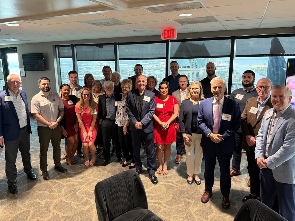 Alumni gather for a group photo at a reception in Tampa