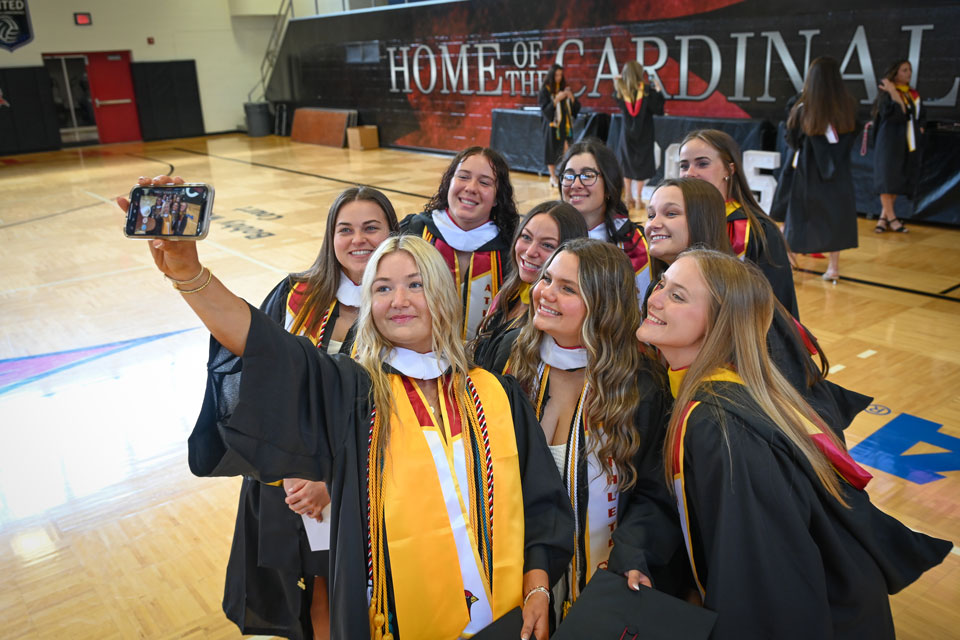 A group of graduates take a selfie before their Commencement ceremony.