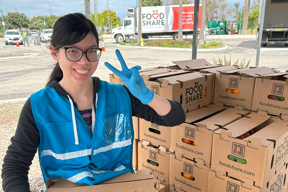 A pharmacy student volunteers at a foodbank in her community.