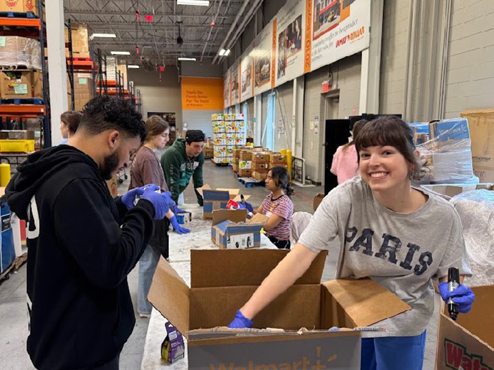Fisher students pack boxes at a food bank during the Campus Ministry alternative Spring Break.