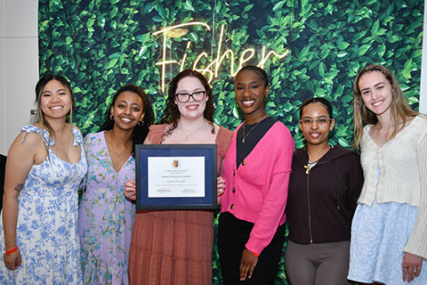 A group of female students one holding an award