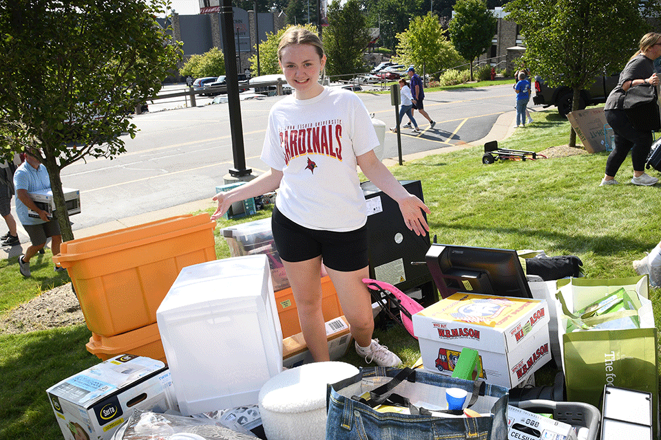 A student surrounded by boxes during Move-In 2023.