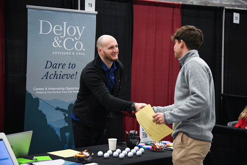 A student talks with a potential employer at the Spring 2024 Career Fair.