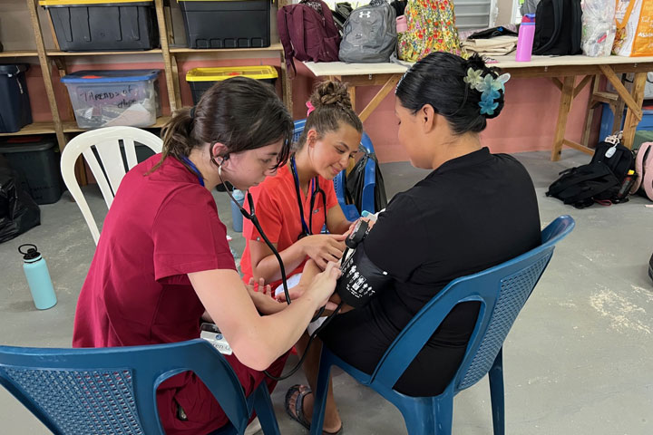 Nursing students see a patient at a clinic in Belize.