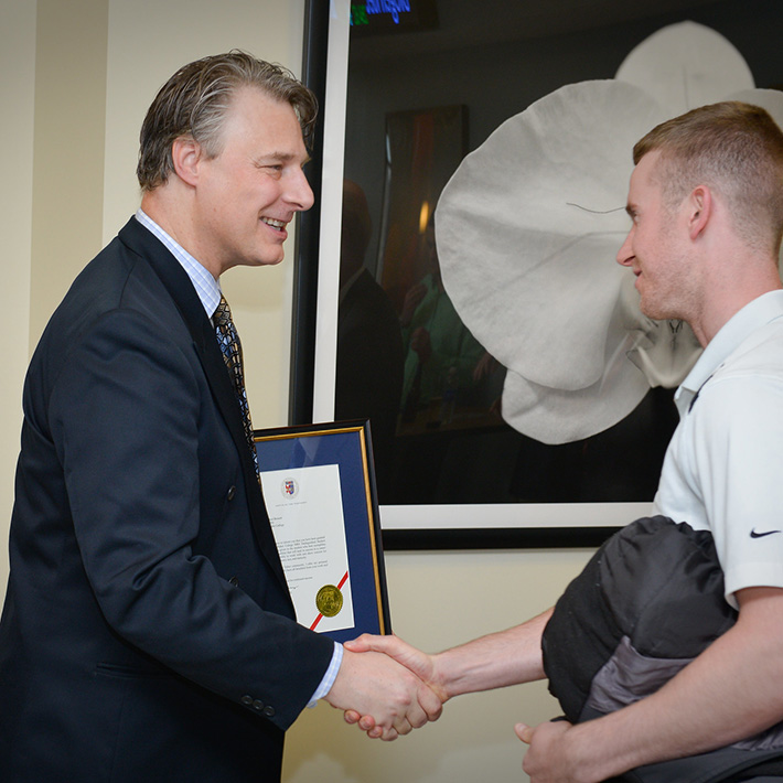 David Kunsch shakes an award-winner's hand.