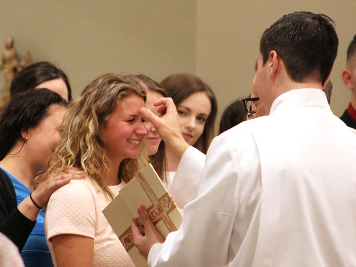 A student receives a blessing in the Hermance Family Chapel of St. Basil the Great