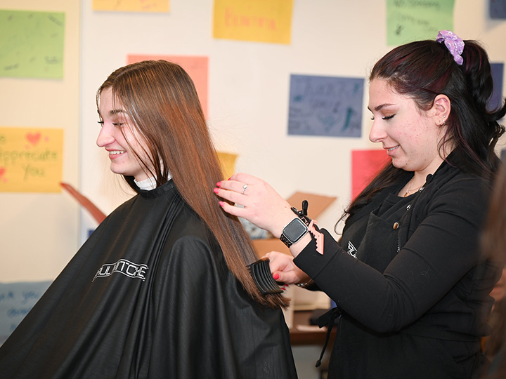 A student gets her hair cut at the Teddi Dance for Love.