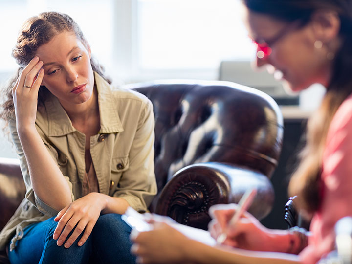 A patient talks while a counselor takes notes.